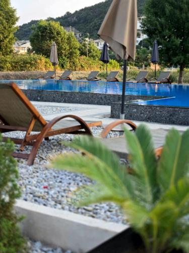 a pool with chairs and an umbrella and a swimming pool at Lula Apartments 2 in Ulcinj