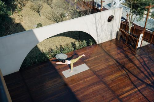 an overhead view of a woman doing yoga on a deck at Hegu Retreat Qingcheng in Jiezi Ancient Town