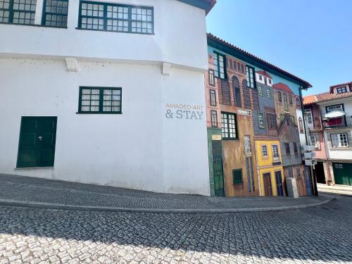 a building with a sign on the side of a street at Amadeo Art&Stay Apartments in Amarante