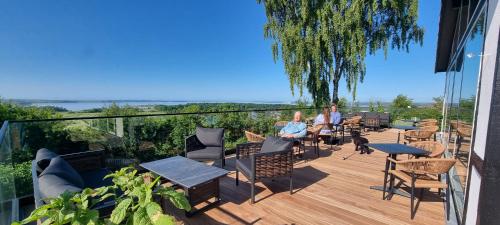 two people sitting on a deck with chairs and tables at Danhostel Rønde in Rønde