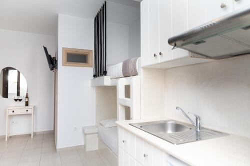 a white kitchen with a sink and a counter at Depis place & apartments naxos in Naxos Chora
