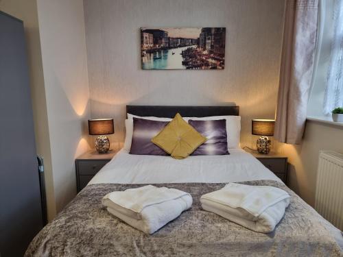 a bedroom with a bed with two pillows on it at Ricky Road Guest House - Premium in Watford