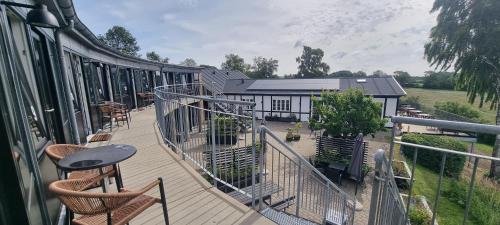 a balcony with chairs and a table and a building at Danhostel Rønde in Rønde