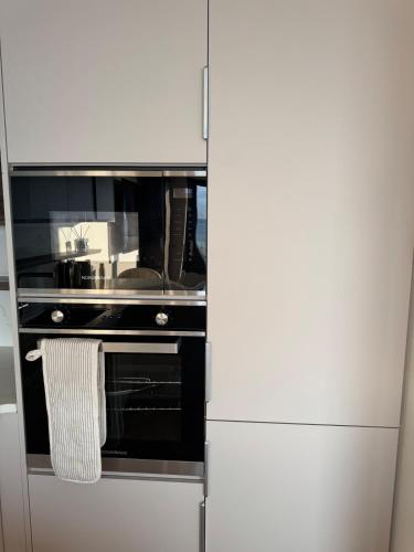 a kitchen with an oven with a towel hanging from it at Sapphire Shores- Spacious 2-Bedroom Apartment with Balcony & Sea View in Portstewart