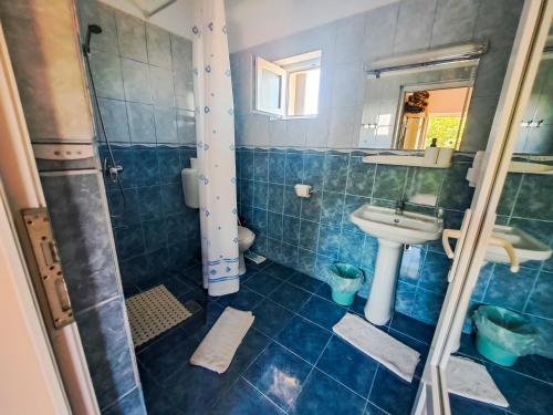 a blue tiled bathroom with a sink and a shower at Pensiunea Mioara 2 Mai in 2 Mai