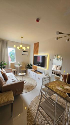 a living room with a couch and a tv at Lumiére Soleia 1BR Sunset View Up to 6 Guests in Butuan