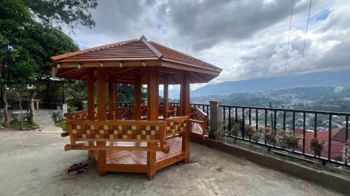 a wooden gazebo sitting on top of a balcony at Newlives Transient 2 Hillside - 1st Floor in Baguio