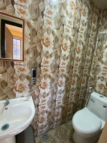 a bathroom with a sink and a toilet and a mirror at Newlives Transient 2 Hillside - 1st Floor in Baguio
