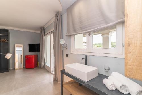 a bathroom with a white sink and a window at Dimora l'Approdo in Santa Teresa Gallura