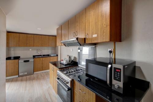 a kitchen with wooden cabinets and a stove top oven at Two Seasons Hotel & Apartments in Dubai