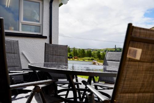 a table and chairs on a patio with a view at Ogham View in Mountfield