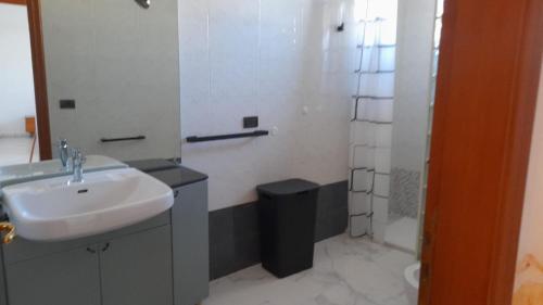 a white bathroom with a sink and a shower at Finestra su Velia in Marina di Ascea