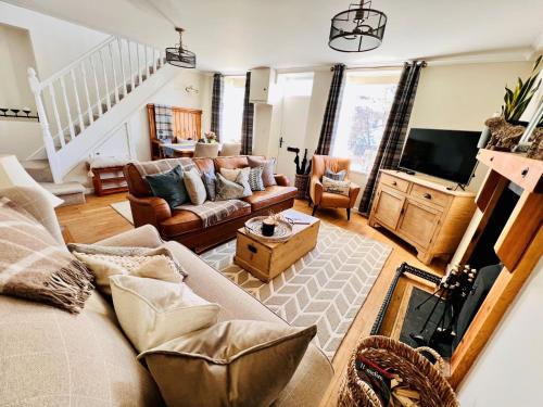 a living room with a couch and a tv at 4 Walkers Cottage - Countryside Retreat with BBQ Hut in Pont Sticill