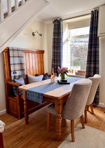 a dining room with a table and a couch at 4 Walkers Cottage - Countryside Retreat with BBQ Hut in Pont Sticill