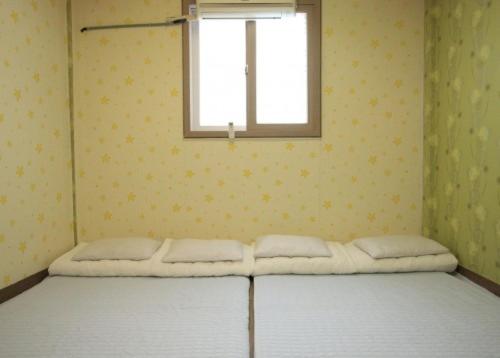 a bed in a room with a window at Gyeongju Friend Guesthouse in Gyeongju