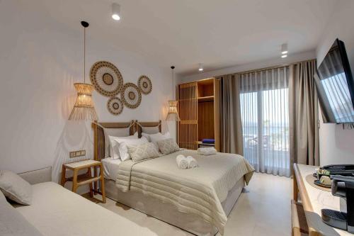 a hotel room with a bed and a television at Linari Sea & Suites in Ormos Panagias
