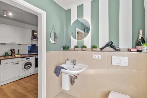 a bathroom with a sink and a washing machine at Ruhiges Innenstadt Apartment in Hamburg