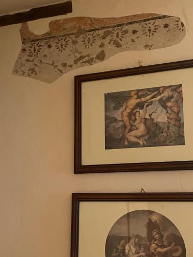 two framed pictures on a wall with a ceiling at Dai nonni di Preteto in Veccialone
