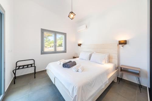 a bedroom with a white bed with two towels on it at Costa Mediterranea in Gaios