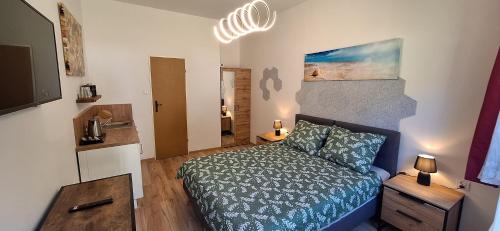 Habitación pequeña con cama y lámpara de araña. en Marina Apartamenty, en Rozewie