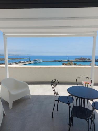 a patio with two tables and chairs and a view of the ocean at Sikelia Suite Rooftop in Porto Empedocle