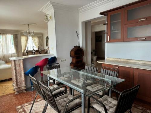 a dining room with a glass table and chairs at Terrace NANA in Tbilisi City