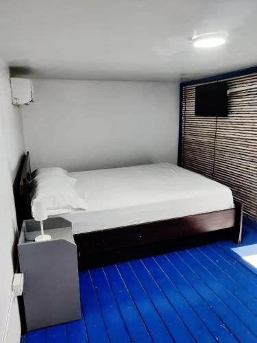 a bed in a room with a blue floor at Hostel capicua in Punta Cana