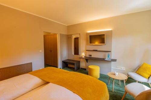 a hotel room with a bed and a table and chairs at Ferien Hotel Cottbus in Kolkwitz