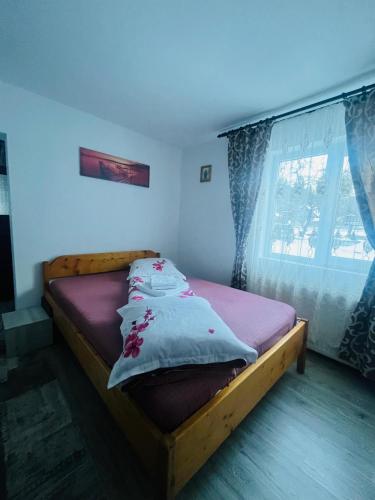 a bedroom with a wooden bed with pillows on it at Casa Ovidiu in Pojorâta
