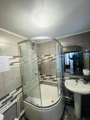 a bathroom with a glass shower and a sink at Casa Ovidiu in Pojorâta
