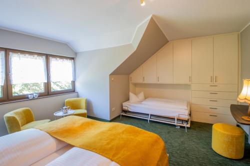 a bedroom with two beds and two chairs at Ferien Hotel Cottbus in Kolkwitz