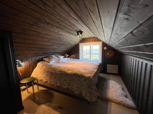una camera con un grande letto in un soffitto in legno di Bjødnabakkens fjellutsikt a Beitostøl