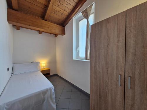 a small bedroom with a bed and a window at Maisonnette terrace in Lierna