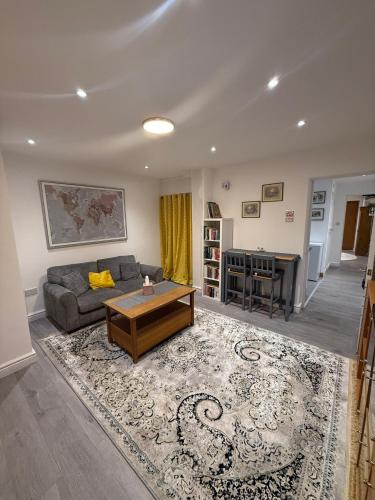 a living room with a couch and a table at Bright and Spacious Entire One Bedroom Apartment with Living Room and Private Garden in London