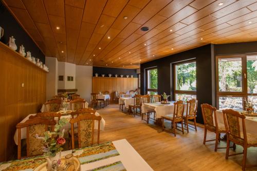 a dining room with tables and chairs and windows at Ferien Hotel Cottbus in Kolkwitz