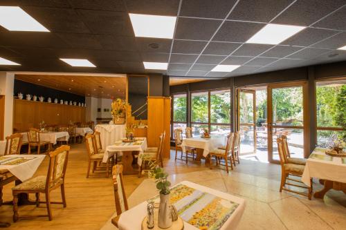 a dining room with tables and chairs and windows at Ferien Hotel Cottbus in Kolkwitz