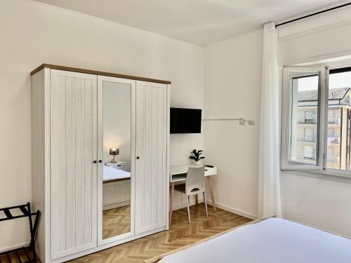 a white bedroom with a desk and a bed at Dimora Francesco in Domodossola