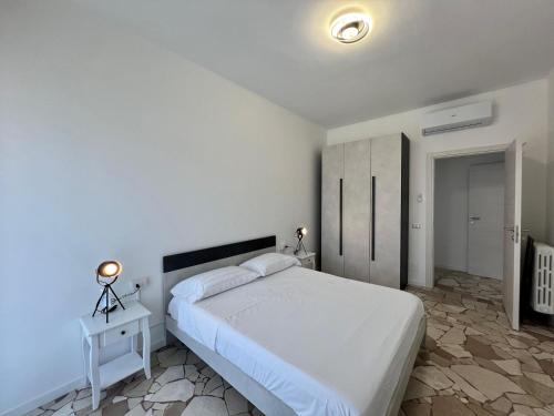 a bedroom with a white bed and a white cabinet at Dimora Francesco in Domodossola