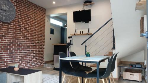 d'une salle à manger avec une table, des chaises et un mur en briques. dans l'établissement Le petit Drapiers 4 Pers a 5 Minutes a pied du petit port et 10 Mins de la plage, au Havre