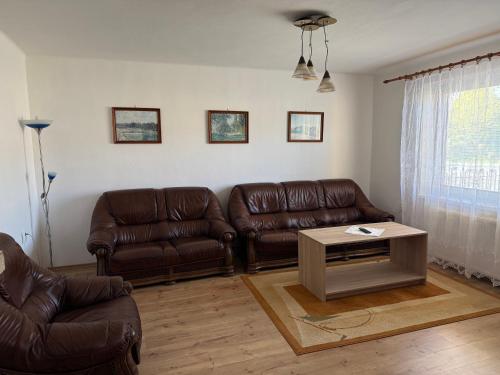 a living room with two leather couches and a coffee table at Dom Udavské in Udavské