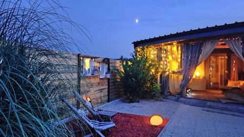 a home with a patio with two chairs and lights at Mobile Home Cabana with HotTub&Sauna in Spodnja Polskava
