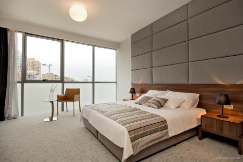 a bedroom with a large bed and large windows at Priska Med Luxury Rooms in Split