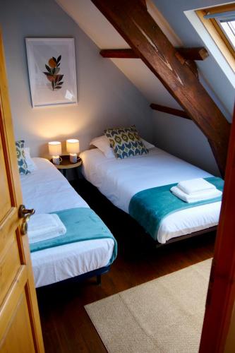 Cette chambre mansardée comprend 2 lits et 2 lampes. dans l'établissement Charme & comfort, Terrace, 5 minutes by boat from Lorient, à Locmiquélic