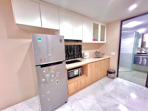 a kitchen with a refrigerator with many magnets on it at HPT Home II Hoàng Huy Riverside Apartment - Homestay chuỗi căn hộ Hải Phòng in Hai Phong