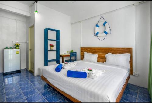 a bedroom with a large white bed with blue accents at La Casa Residencies in Patong Beach