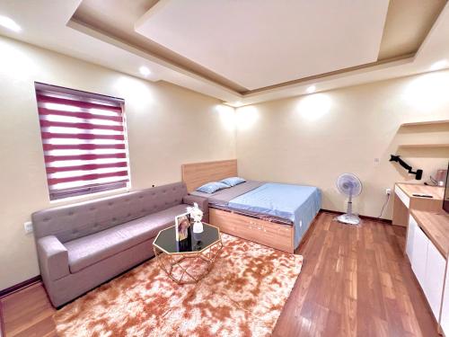 a room with a bed and a couch and a window at HPT Home II Hoàng Huy Riverside Apartment - Homestay chuỗi căn hộ Hải Phòng in Hai Phong