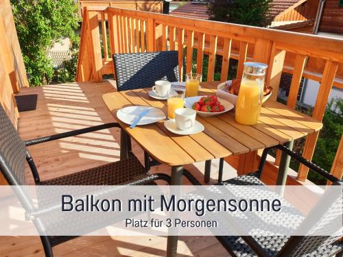 a wooden table with a bowl of fruit and orange juice at Ferienhaus Inntal - Ferienwohnung Naunspitz - ruhig schlafen, zentral starten, beliebt bei Wanderern in Kiefersfelden