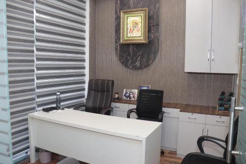 an office with two chairs and a white desk at Hotel Signature Inn in Vrindāvan