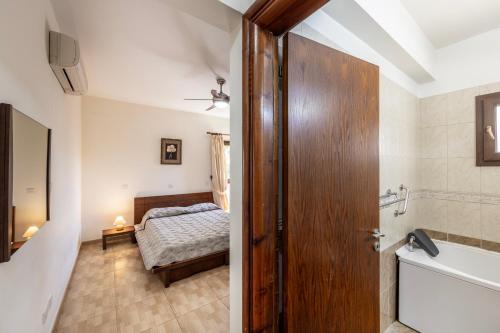 a bathroom with a tub and a bedroom with a bed at Villa Tsikkos Dio in Limassol