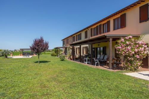 a building with a yard with chairs and flowers at La Sosta di Braccio in Macchie